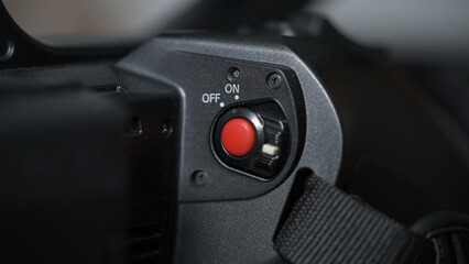 Red record button of black professional camcorder