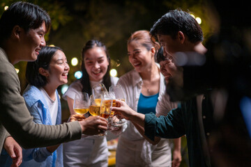 A group of people are gathered around a table, raising their glasses to toast