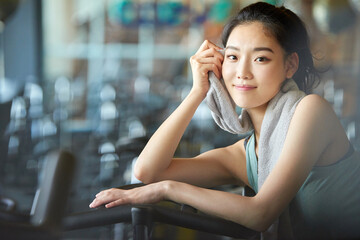 Asian Woman Resting on Exercise Bike at Gym