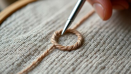 Close-up of hand embroidering twisted thread on fabric with needle