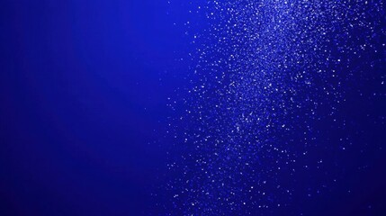 Fototapeta premium Energetic motion of falling confetti over a rich, bold blue background for celebration visuals