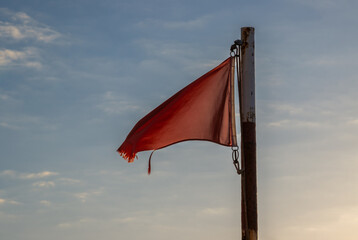 Red flag on a beach and blue sky, Spain