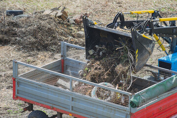 A construction loader is dumping debris into the van's bed — a close-up of heavy municipal...