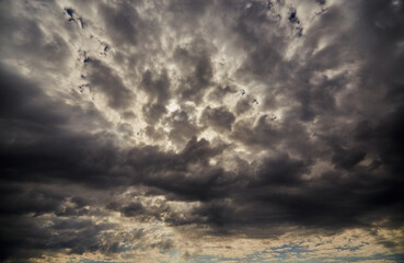 A large shelf cloud on a dark sky blocking sunlight, close-up, cloud background, gloomy tones of the evening sky before rain, texture of dark clouds in the sky, ominous clouds in the sky
