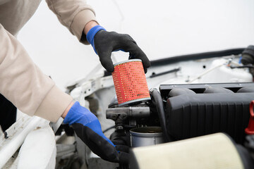 Car Mechanic Changes Oil Filter While Servicing a Vehicle in an Auto Repair Shop
