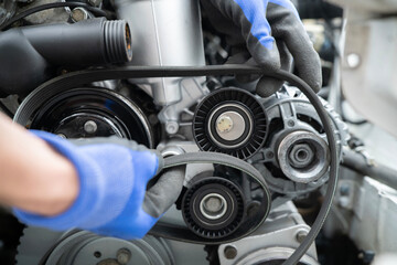 Fototapeta premium Mechanic Working on Car Timing Belt Replacement Under the Hood in Automotive Workshop