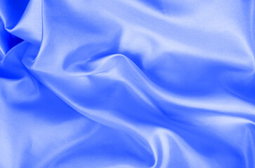 Top view of light blue color silk in soft, smooth waves with a glossy finish. Suitable for design and wallpaper background