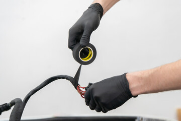 Wiring Connections Being Insulated With Tape to Ensure Safety and Functionality in a Vehicle Repair...