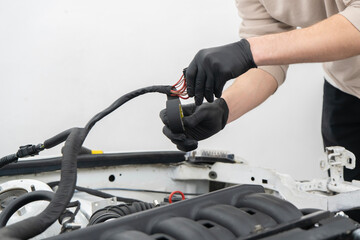 Wiring Connections Being Insulated With Tape to Ensure Safety and Functionality in a Vehicle Repair...