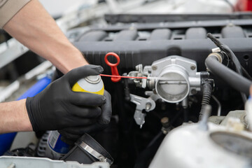 Spraying Throttle Valve Cleaner in a Car Engine for Effective Maintenance and Improved Performance