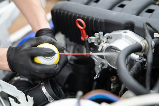 Spraying Throttle Valve Cleaner in a Car Engine for Effective Maintenance and Improved Performance