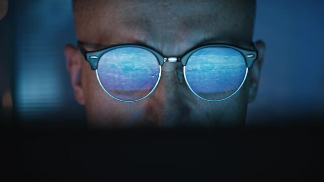 Focused Male scientist working on a computer in a futuristic research laboratory. computer screen displaying 3d model of a medical document in glasses
