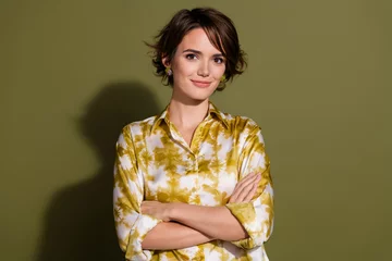 Fotobehang Confident young businesswoman against a khaki backdrop, professional style for advertising and career success in the corporate world. © deagreez