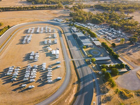 Aerial view of dozens of motorhomes parked at a racetrack
