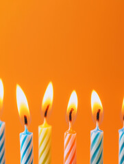 Colored thin burning birthday candles. Orange background. Holiday candles for cake. Happy birthday card, copyspace for your text.	

