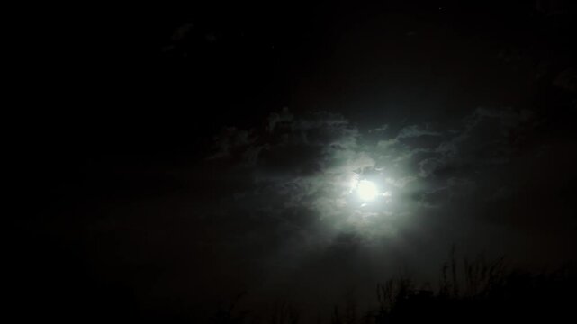 Timelapse artistique de la lune &agrave; travers les nuages au S&eacute;n&eacute;gal, rayons lumineux c&eacute;lestes dans le ciel nocturne africain, ambiance mystique et po&eacute;tique sous la vo&ucirc;te &eacute;toil&eacute;e