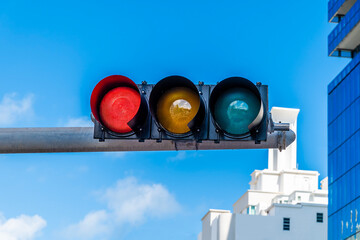 A view of a red illuminated traffic light above Collins Avenue in South Beach in Miami in springtime