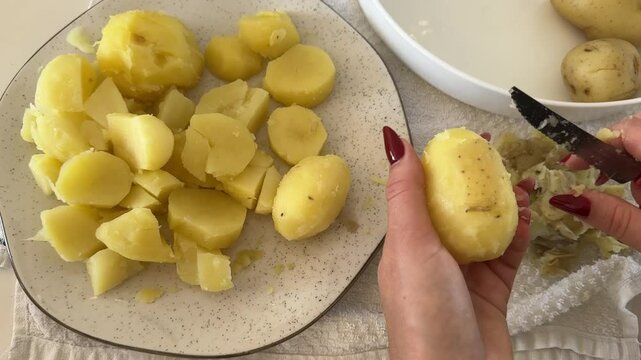 mulher descasca batatas preparando almo&ccedil;o 