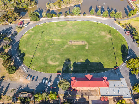 Aerial view of a road surrounding a football oval and grandstand