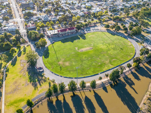 Aerial view of a road surrounding a football oval and grandstand