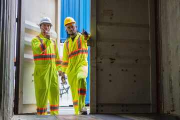 Engineer man Team in Safety Gear Inspecting Containers Box at Industrial Site, Container Yard Dock...