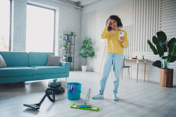 Young woman tidying up in stylish living room during daytime with natural light