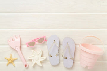 Children's flip flops and beach toys on wooden background,,top view