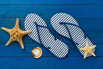 Striped blue flip flops on wooden background, top view