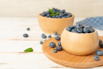 Bowl with fresh blueberries on wooden table