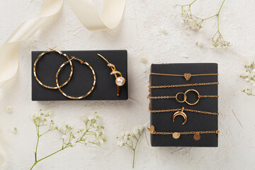 Elegant golden jewelry with decoration on concrete background, top view