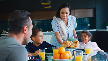 Hispanic Family Sitting Around Table Eating Breakfast Together