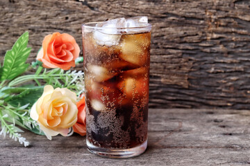 Cola drink with ice cubes and rose flower