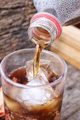 Pouring cola drink on glass