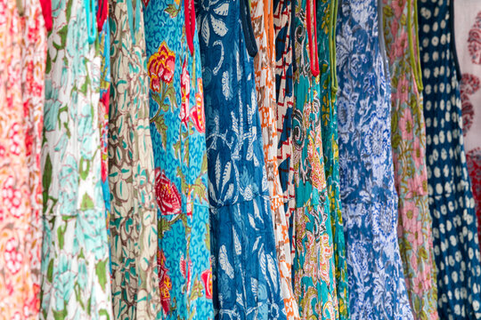 Colourful pattern dresses in a row at a market stall