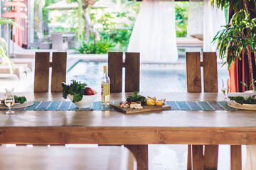 Young couple in love sitting at table having dinner together satisfied with tasty meal and conversations, smiling caucasian young woman eating with her husband at home with natural materials interior