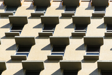 A pattern of windows and shadows on the wall of a building