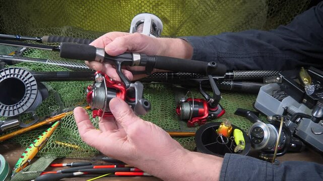 The hands of an elderly fisherman are engaged in the manufacture and assembly of fishing gear.
