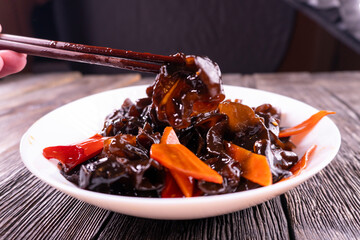 Wood ear mushrooms with vegetables on dark background. vegan food