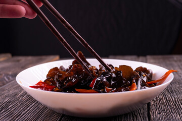 Wood ear mushrooms with vegetables on dark background. vegan food