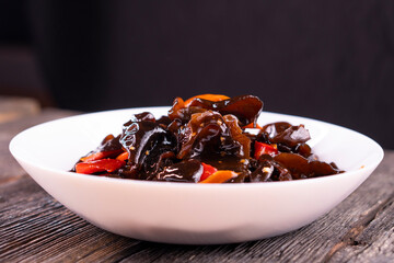 Wood ear mushrooms with vegetables on dark background. vegan food