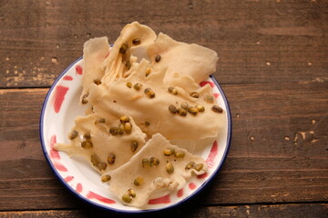 Rempeyek or Peyek is a snack or side dish made from flour with beans, shrimp, green beans, etc., fried in a flat shape. Rempeyek.kacang hijau. Indonesian food