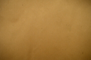 A close-up of a textured brown paper surface, showcasing its natural imperfections and warm, earthy tones, ideal for backgrounds or artistic designs