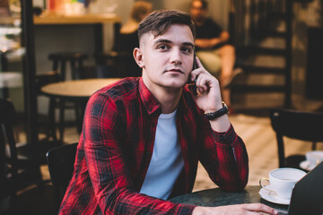 Thoughtful man with laptop in cafe