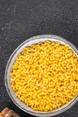 Pasta raw coquillette macaroni appetizer dish organic product fresh tasty gourmet food background on the table rustic food top view copy space