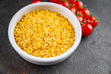 Pasta raw coquillette macaroni appetizer dish organic product fresh tasty gourmet food background on the table rustic food top view copy space