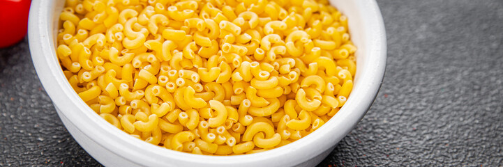 Pasta raw coquillette macaroni appetizer dish organic product fresh tasty gourmet food background on the table rustic food top view copy space