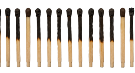 Burnt matches line against black background