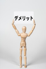 デメリットのカードを持ったデッサン人形