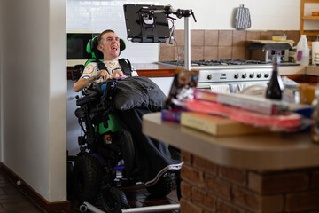 AAC screen set up on a stand in the kitchen for a man in an electric wheelchair