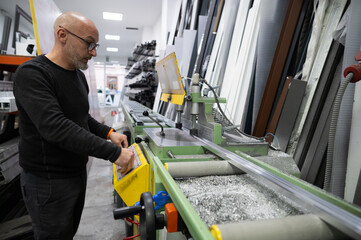 Carpenter operating aluminum cutting machine in workshop